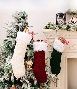 Detailed view of thick knit Christmas stockings with white faux fur trim and cable patterns