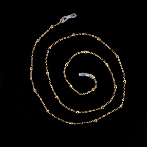 Detail of gold metal glasses chain with small beads and adjustable silicone loops