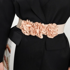Detail of champagne pink elastic waist belt with three 3D silk roses on a black blazer