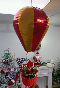 Macro detail of red and gold hot air balloon ornament with holiday gift basket