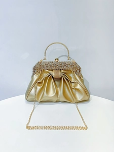 Detail of gold pleated evening clutch featuring crystal rhinestone trim and metallic handle