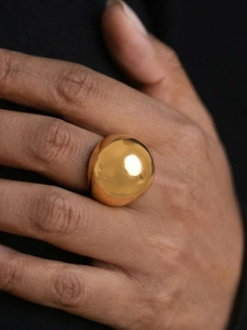 Polished oversized gold sphere statement ring showcasing minimalist geometric design