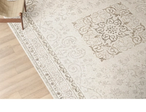 Detailed top view of beige Persian style rug with intricate patterns on wood floor