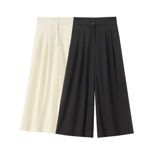 Détail d'un pantalon taille haute à jambes larges avec plis et double boutonnage