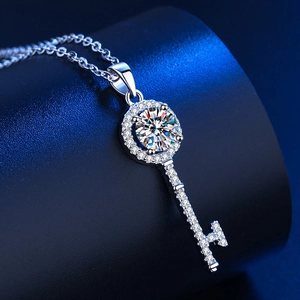 Detailed macro view of a silver key pendant necklace with a brilliant round centerpiece