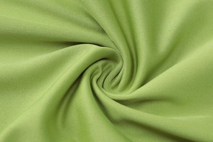 Detailed close-up of light green fine ribbed knit fabric showing soft texture and pleats