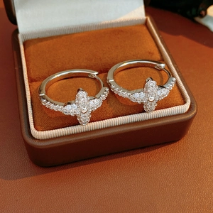 Detailed close-up of clover flower earrings with zircon stones and silver clasp