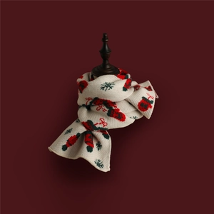 Detail of Christmas knitted scarf with reindeer and snowflake patterns on a cream base