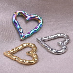 Detailed view of heart charms in rainbow, gold, and silver finishes with hammered texture
