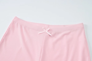 Close-up of pink ribbed knit shorts waist featuring an elastic band and a decorative satin bow