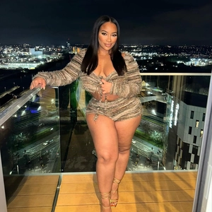 Close-up of a striped long sleeve wrap top and high waist shorts set in a city night scene