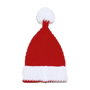 Close-up of a red and white knitted Christmas hat with a fluffy pom-pom and folded cuff