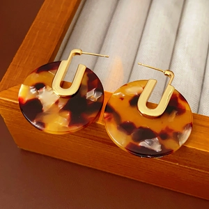 Detailed shot of tortoiseshell acetate hoop earrings with gold plated metal finish