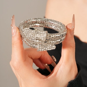 Macro shot of silver snake bracelet with sparkling pavé crystals and black stone eyes