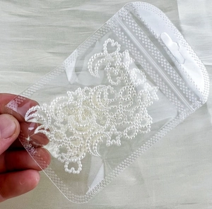 Detail of white faux pearl moon and star shaped face stickers in a clear bag