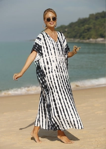 Detail of V-neck beach kaftan featuring black and white vertical tie-dye patterns