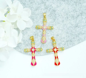 Macro detail of 18K gold plated cross pendants with colorful enamel and inlaid zircon