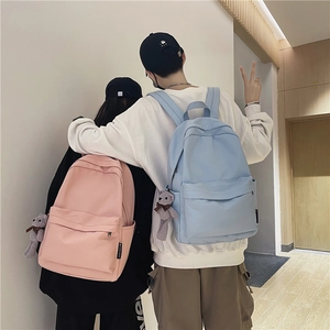 Gros plan sur les sacs de voyage rose et bleu clair avec breloques d'ours et poches latérales