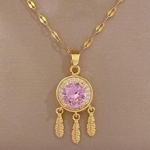 Detailed view of a gold dreamcatcher necklace with pink gemstone and feather charms