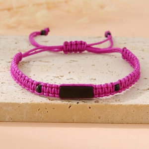 Detail of rose pink handmade woven cord bracelet with rectangular black stone centerpiece