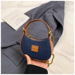 Détail du mini sac bandoulière en denim et cuir avec chaîne dorée et patch logo embossé