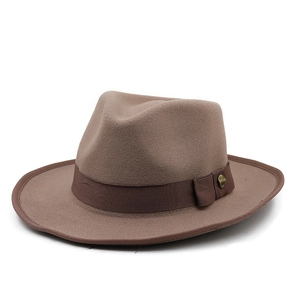 Detail of tan wool fedora hat featuring a dark brown band and bronze buckle accent