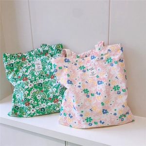 Detail of floral cotton tote bags in pink and green with textile label and soft textures
