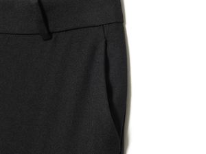 Detail of high-quality black trousers showing waist construction and side pocket texture