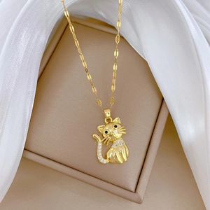Macro view of a gold cat pendant with black eyes and sparkling crystals on a chain