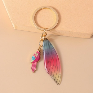 Close-up of luxury magpie wing keychain with enamel bird and glitter resin details