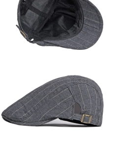 Détail d'une casquette plate grise à rayures avec boucle en bronze et tissu respirant