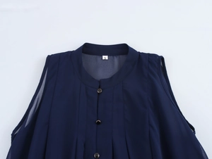 Detailed close-up of dark blue sleeveless chiffon top with size S label and metal buttons