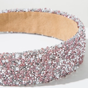 Macro detail of hand-set pink and silver rhinestones with pearls on a wide headband