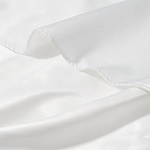 Detailed view of white satin fabric with smooth texture and delicate stitching
