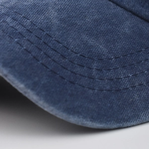 Close-up of washed cotton baseball cap brim with vintage texture and reinforced stitching