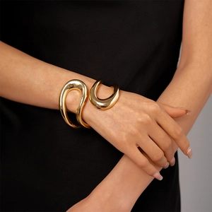 Close-up of gold irregular geometric cuff bracelet with a polished mirror finish on model