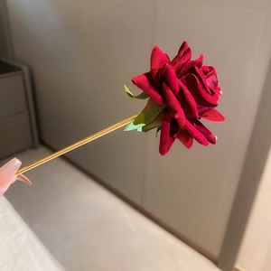 Detailed view of the dark red velvet rose hair stick with a sleek gold-finished metal pin