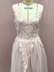 Detail view of pink lace patchwork V-neck wedding dress with floral embroidery and tulle skirt