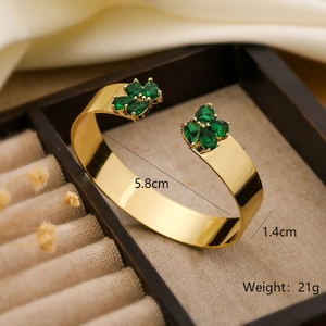 Macro shot showing 18K gold plated cuff bracelet with green gemstones and dimensions