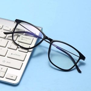 Detail view of anti-blue light glasses with black frame placed on a white laptop keyboard