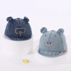 Détail de casquettes de baseball en denim pour bébé avec oreilles d'ours et broderie
