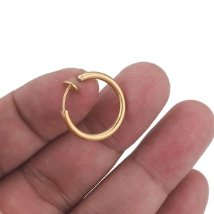 Close-up of a person holding a golden stainless steel invisible spring clip-on earring
