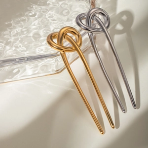 Detailed close-up of 18k gold and silver U-shaped hair pins with sleek knot design