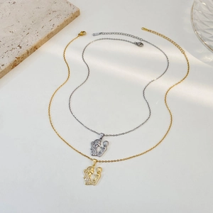 Detailed close-up of mother and child embrace pendant in gold and silver stainless steel
