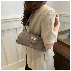 Chic grey faux suede baguette bag worn by model showing minimalist shoulder strap detail