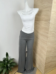 Detailed view of grey flared knit trousers with double-layered waist on white mannequin