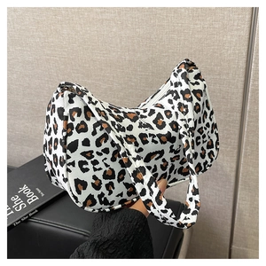 Detail view of leopard print baguette bag with a crescent shape and smooth zipper closure