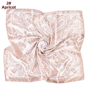 Detail of apricot satin square scarf with white paisley pattern and smooth finish
