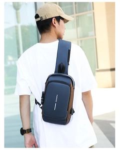 Men's navy and brown crossbody chest bag with adjustable strap shown on model's back