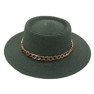Detail of dark green straw boater hat featuring a stylish rose gold metal chain band